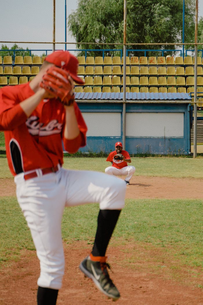 Pitcher throwing a baseball with a catcher in position on a sunny field.